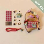 DIY kit materials for Handmade Cozy Piglet Decor arranged beside the finished piglet design on a neutral background