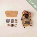 DIY kit materials for Chestnut Pocket Pig Pod Doll arranged beside the finished design on a neutral background