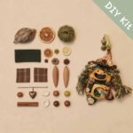 DIY kit materials for Open-Mouth Pod Doll Moss Heart Witch arranged beside the finished design on a neutral background