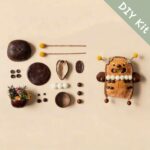 DIY kit materials for Open-Mouth Pod Doll Sunny Bloom Bug arranged beside the finished design on a neutral background