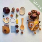 DIY kit materials for Open-Mouth Pod Doll Corn Spoon Piglet arranged on a neutral background beside the finished design
