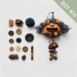 DIY kit materials for Open-Mouth Pod Doll Charm Midnight Chime arranged on a neutral background beside the finished design