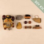 Pocket Tiger Cub pod doll DIY kit with fabric pocket, tail piece, buttons, and handmade parts laid flat