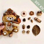 Woodland Bouquet Red Panda pod doll DIY kit with flower basket, acorn details, floral accessories, and handmade materials on a beige background