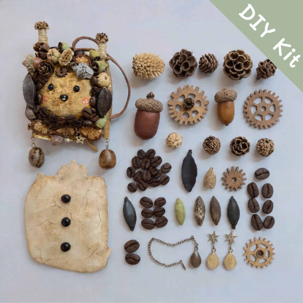 DIY kit flat lay for Coffee Grove Sprite pod doll with finished sample, blank body piece, coffee beans, acorns, wooden gears, seed pods, and decorative metal charms.