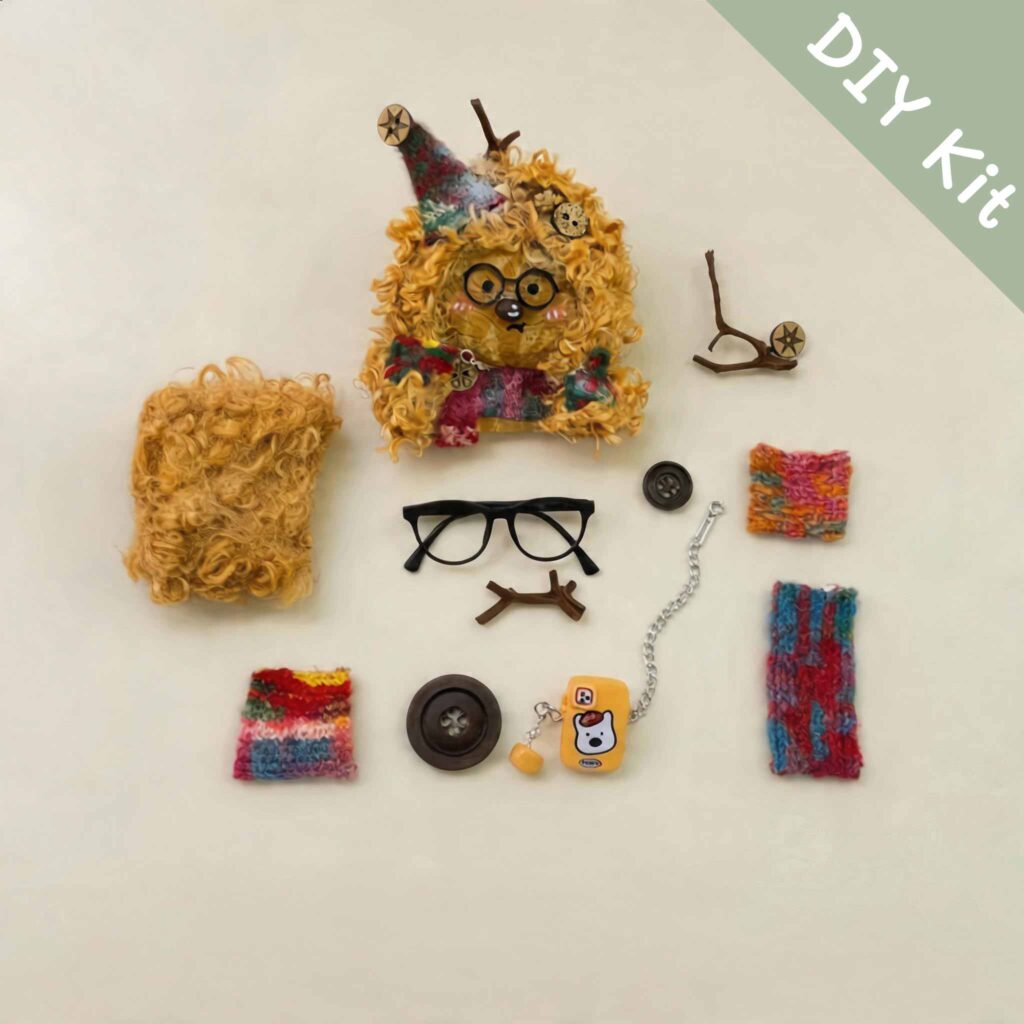 Fuzzy Glasses Monster Pod Doll DIY Kit flat lay with glasses, colorful fabric pieces, mini accessories, and fluffy material components
