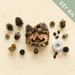 Open-Mouth Pod Doll Woodland Fox DIY Kit flat lay with fox face piece, pinecones, acorns, coffee beans, and ribbon materials