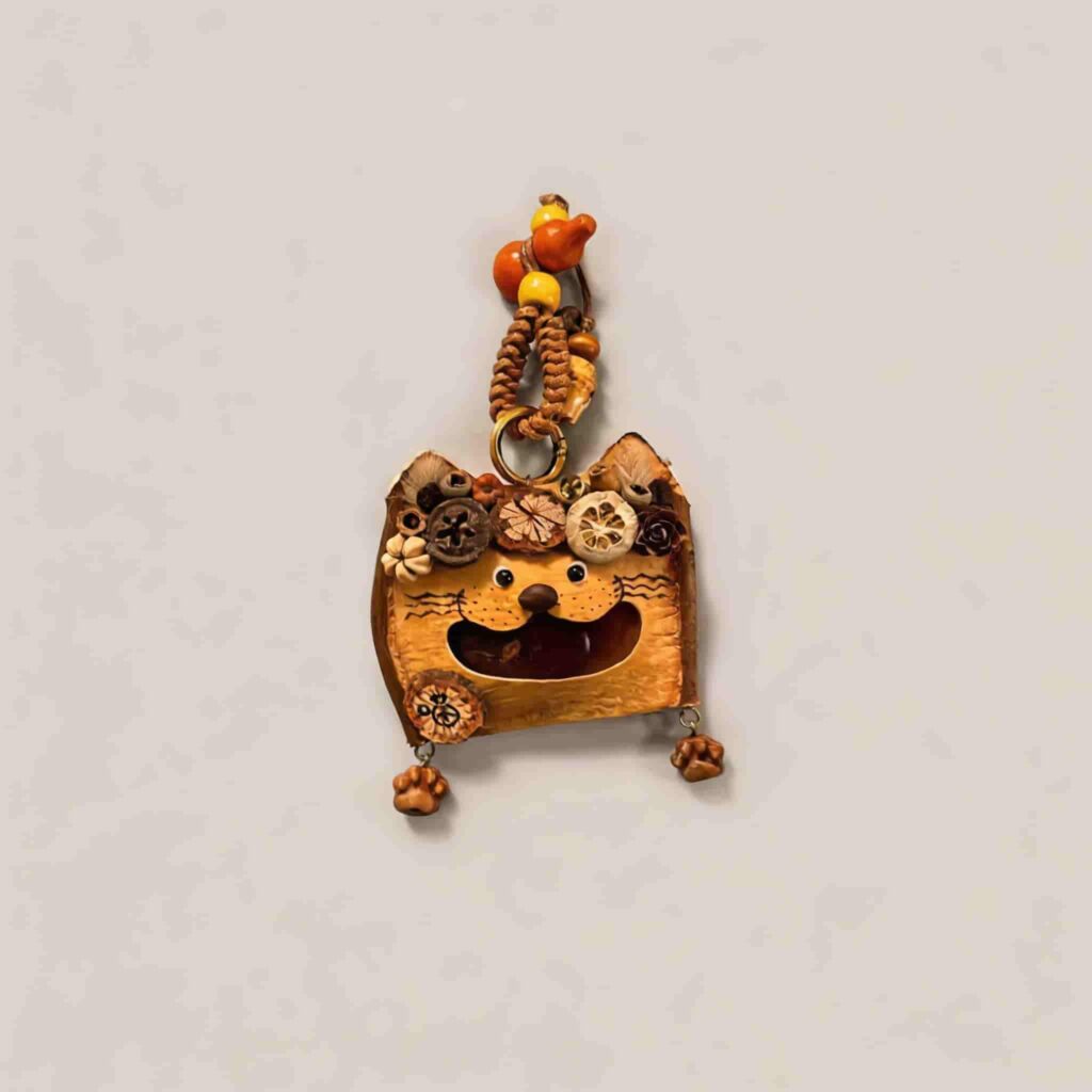 Open-Mouth Pod Doll Pumpkin Whisker Kitty with cat-shaped silhouette, whisker details, and dangling paw charms on a neutral background