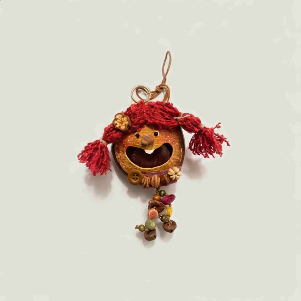 Front view of Berry Tassel Sprite handmade pod doll charm with joyful wide smile and bright red yarn pigtails