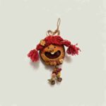 Front view of Berry Tassel Sprite handmade pod doll charm with joyful wide smile and bright red yarn pigtails