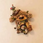 Open-Mouth Pod Doll Basket Witch Forager with curly caramel hair, tall woodland hat, and miniature basket on a neutral background