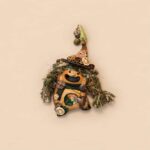 Open-Mouth Pod Doll Moss Heart Witch with mossy green textured hair, tall witch hat, and dangling heart charm on a neutral background