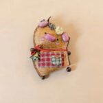 Handmade Cozy Piglet Decor with pink piggy details, red cord accent, and plaid pocket on a neutral background