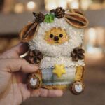 Close-up of handmade Clover Star Lamb pod doll held in hand with fluffy curls, clover detail, and woodland-inspired decorations