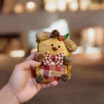 Handheld Red Plaid Acorn Puppy pod doll showing plaid fabric detail, puppy face, seed pod ears, and woodland-inspired decorations