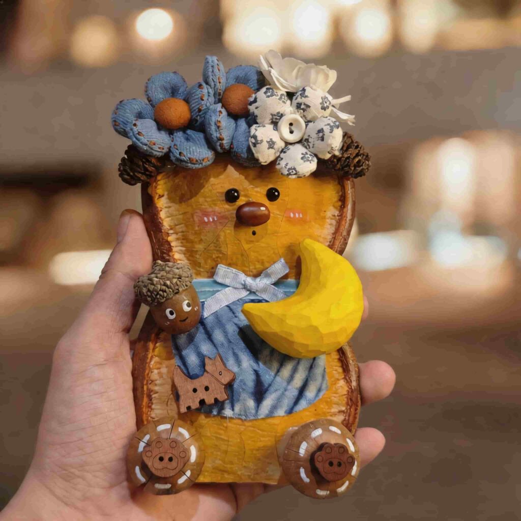 Handmade Moonlit Blue Blossom Bear pod doll held in hand with dreamy warm background