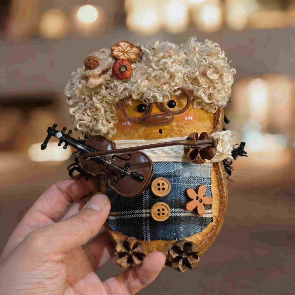 Handmade Cozy Violin Duck pod doll being held in hand with a miniature violin and warm woodland styling