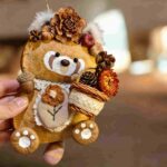 Handmade Woodland Bouquet Red Panda pod doll being held in hand with a tiny flower basket and woodland floral details