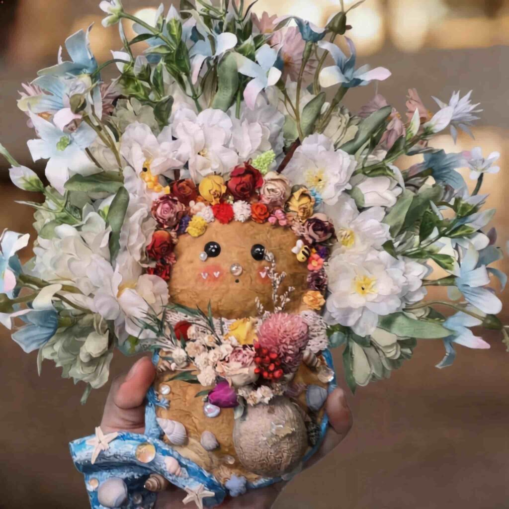Close-up of the pod doll’s floral crown and bouquet details with layered blooms and coastal styling