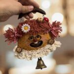 Close-up of a cottagecore pod doll ornament with lace collar, gingham bows, tiny glasses, and smiling face