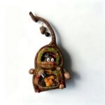 Close-up of the upper window and hanging branch detail on a handmade forest pod house ornament