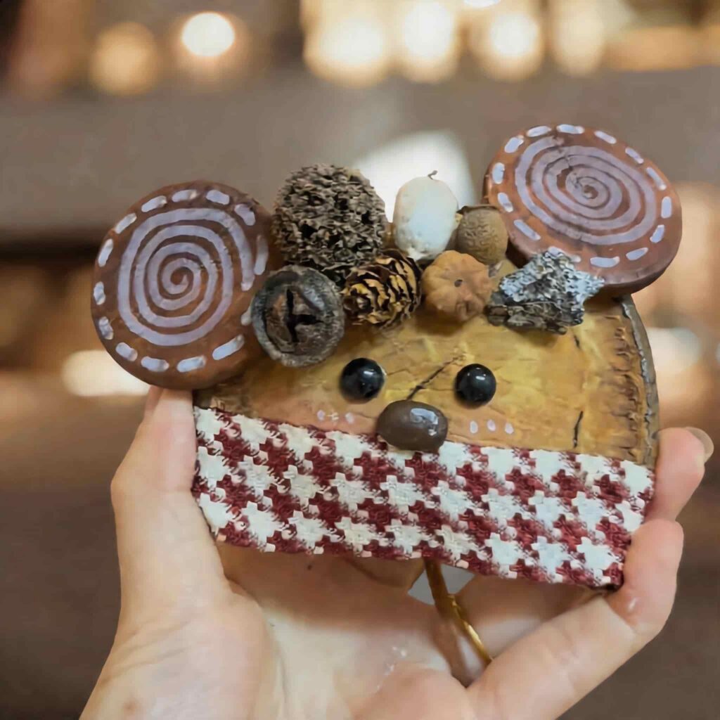 Handheld view of Cinnamon Whisker Mouse pod doll with rustic woodland details and spiral mouse ears