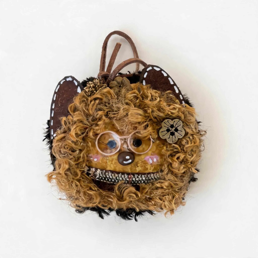 Handmade curly cat pod doll charm with fluffy textured hair, glasses, and cat ear details on a clean background