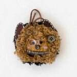 Handmade curly cat pod doll charm with fluffy textured hair, glasses, and cat ear details on a clean background