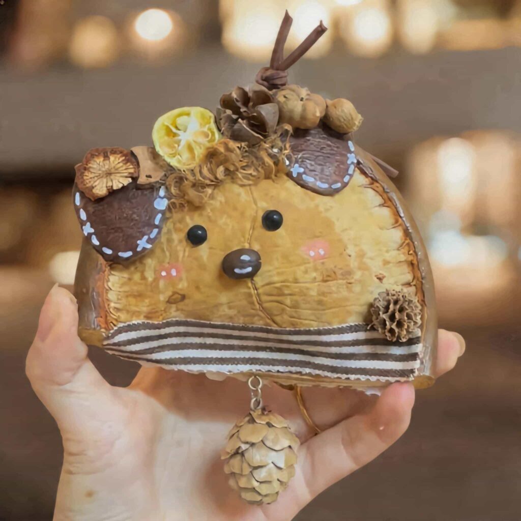 Handheld Citrus Walnut Mouse Pod Doll with striped trim, walnut accents, and pinecone charm