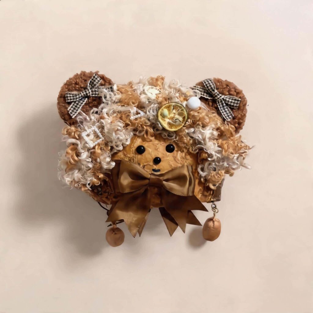 Handmade Pod Doll Mocha Ribbon Bear held in hand, showing soft curly texture, teddy bear styling, and neutral brown tones