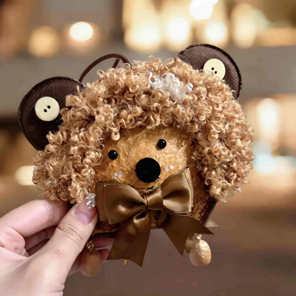 Handmade bear pod doll with curly hair and mocha bow held in hand