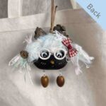 Double-Sided Pod Doll – Frostmint Peace Bean back view with white glasses and red bow displayed on a canvas tote bag