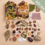 Front view of handmade woodland pod doll with layered moss details, tiny mushroom, and miniature forest scene