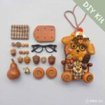 Handmade Forest Scholar Wagon pod doll with round black glasses, plaid body, and woodland seed details on a neutral background