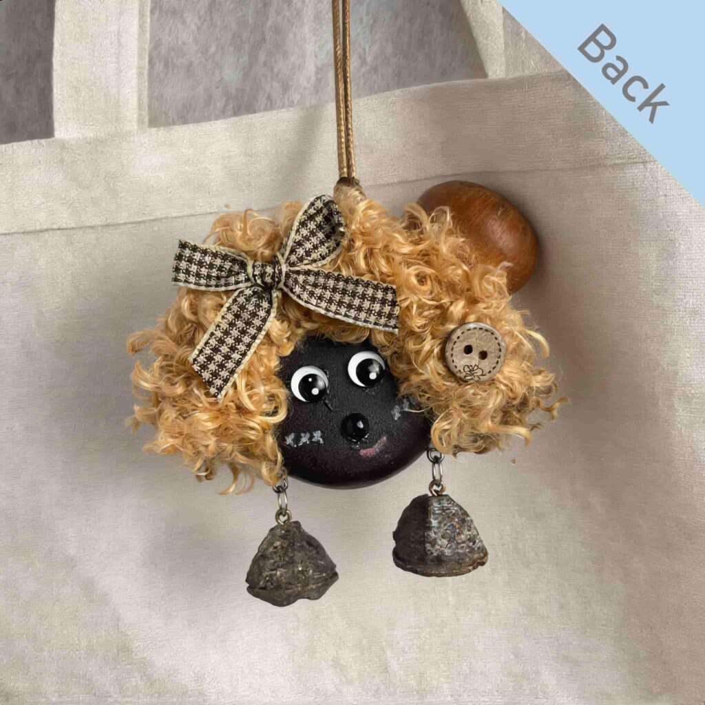 Double-Sided Pod Doll Cocoa Curl Pixie back view hanging on a canvas bag