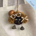 Double-Sided Pod Doll Cocoa Curl Pixie front view hanging on a canvas bag