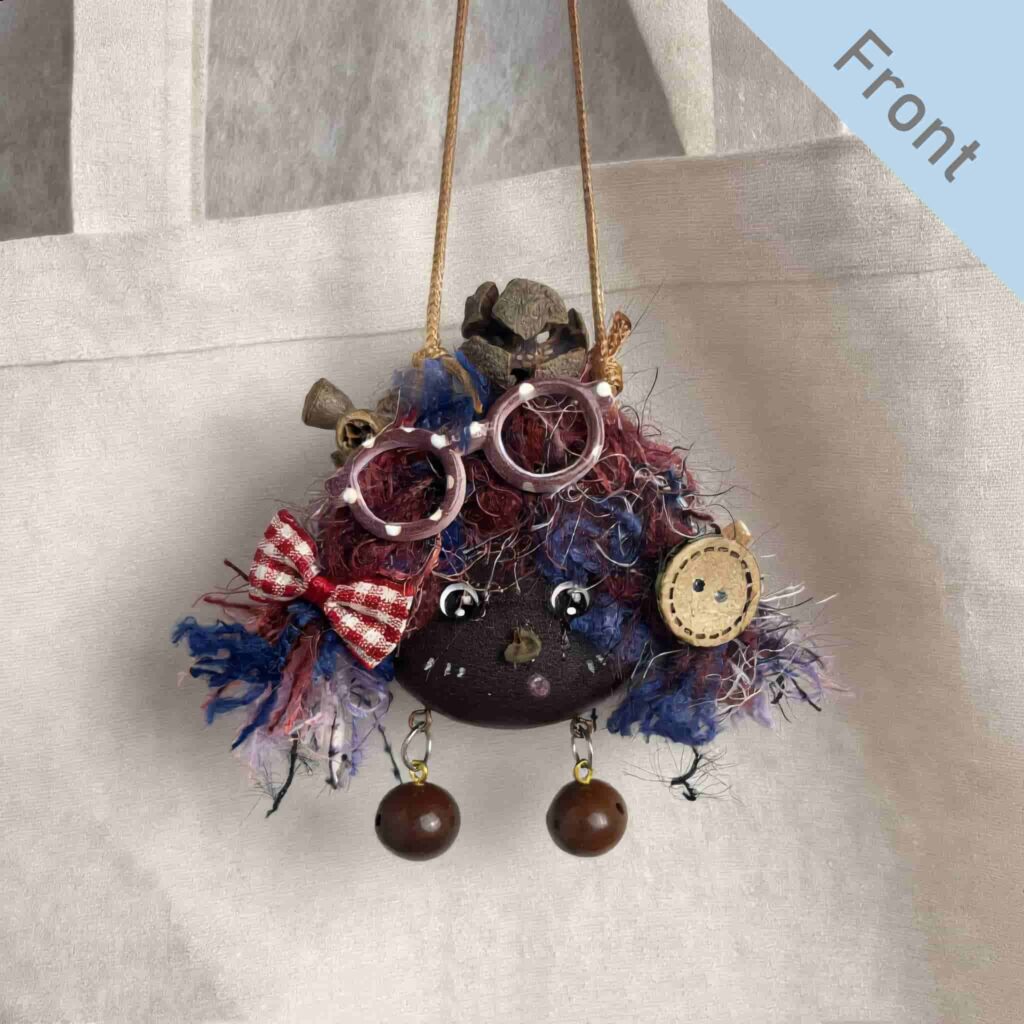 Double-Sided Pod Doll Berry Button Pixie front view hanging on a canvas bag