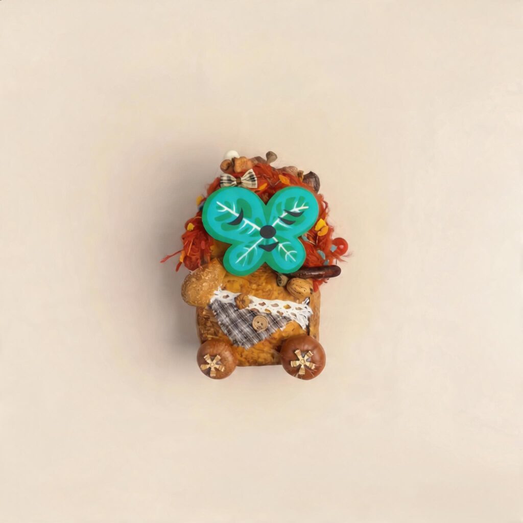 Studio shot of the double-sided pod doll with a magnetic green clover-style face attached on a clean beige background.