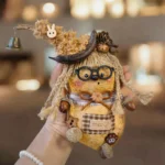 Finished Pod Doll – Bird with Glasses showing seed-pod body, beak, curly hair, bunny charm, and bell