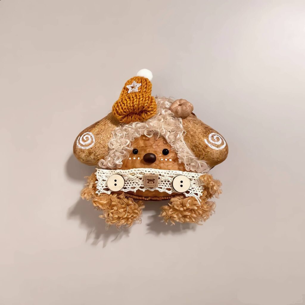 Close-up detail of Brown Bear Pod Doll's orange yarn hair and lace