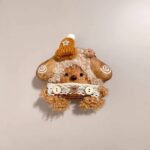 Close-up detail of Brown Bear Pod Doll's orange yarn hair and lace