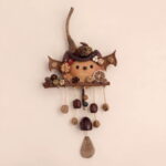 Close-up detail of Pod Doll – Bat, highlighting seed-pod flowers and hand-painted features