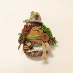 Close-up detail of finished Pod Doll head with orange eye circle and green hat