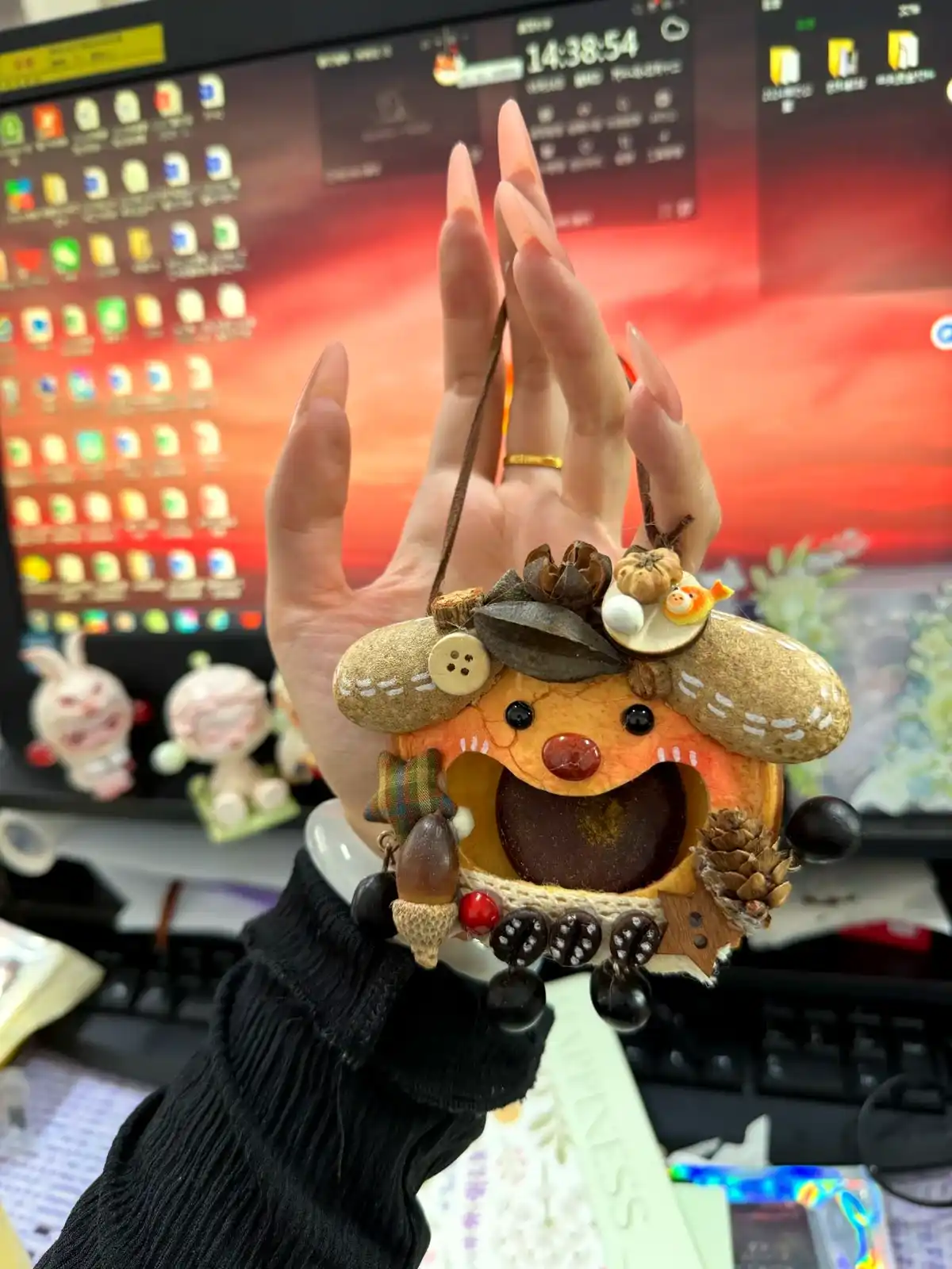 Customer holding an open-mouth handmade pod doll near a desk