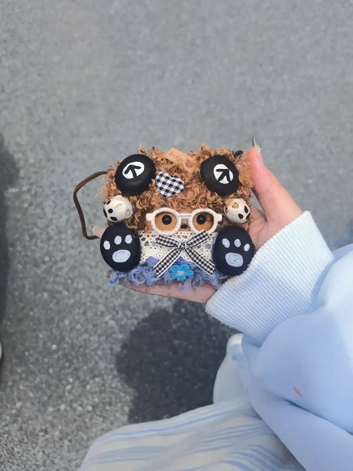 Customer holding a panda-style handmade pod doll outdoors