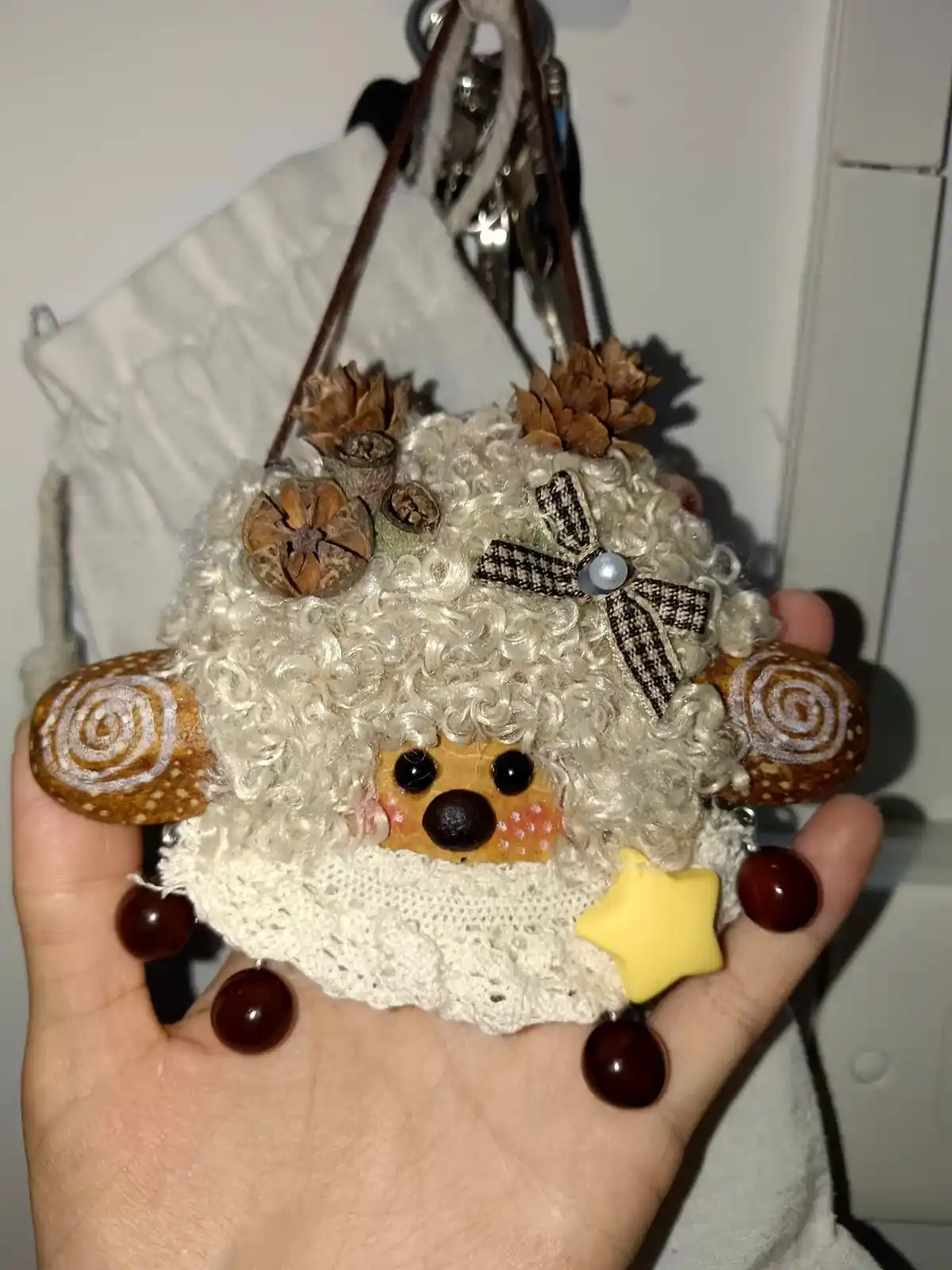 Customer holding a handmade pod doll with white curly hair and small details