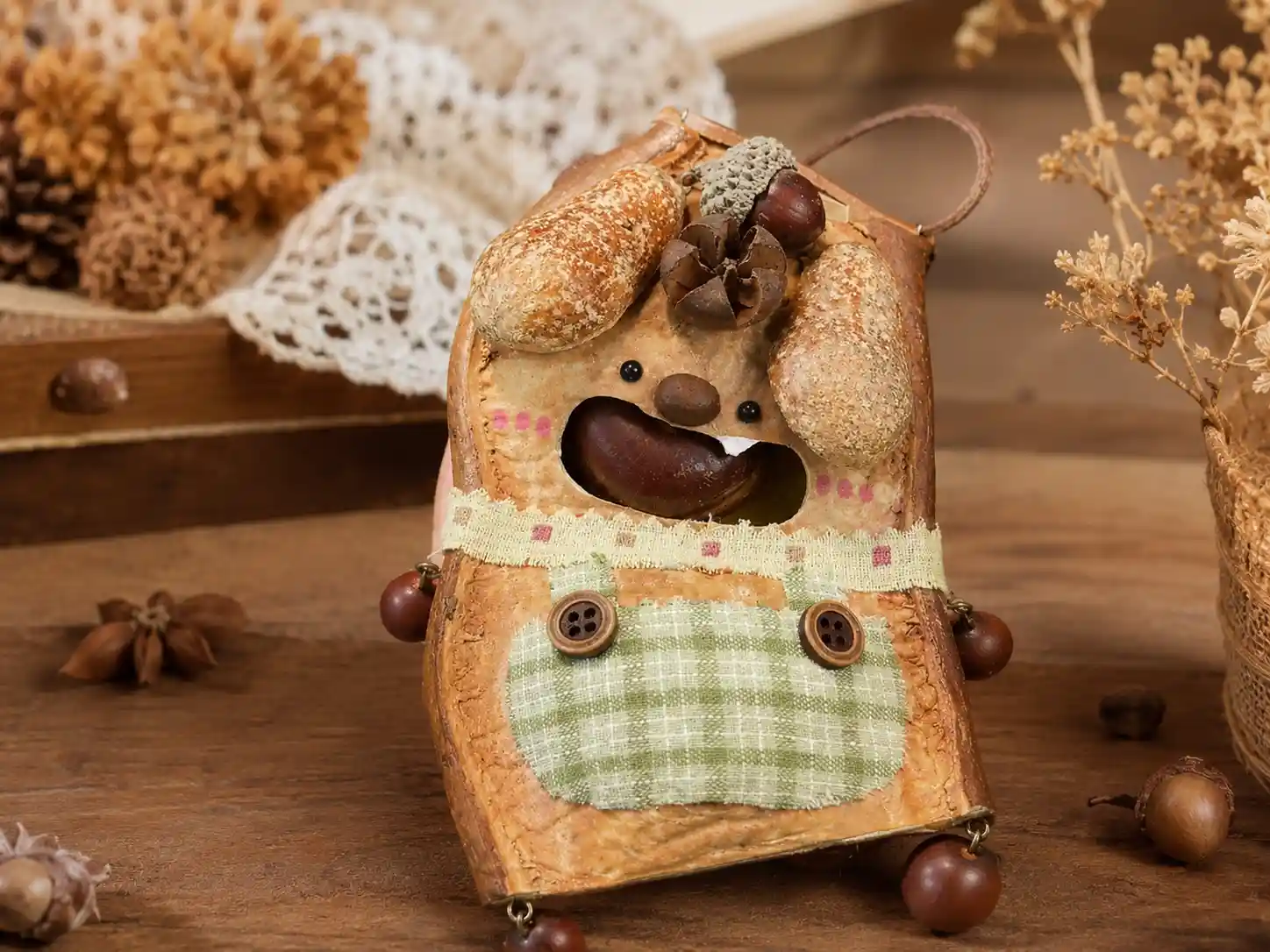 Finished handmade pod doll made from a whole natural seed pod shell with seed accessories, fabric details, and button accents