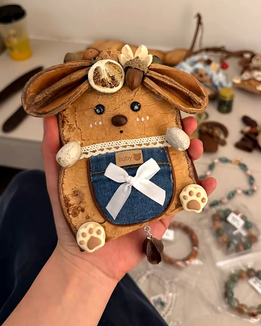 Handmade pod doll held gently in hand