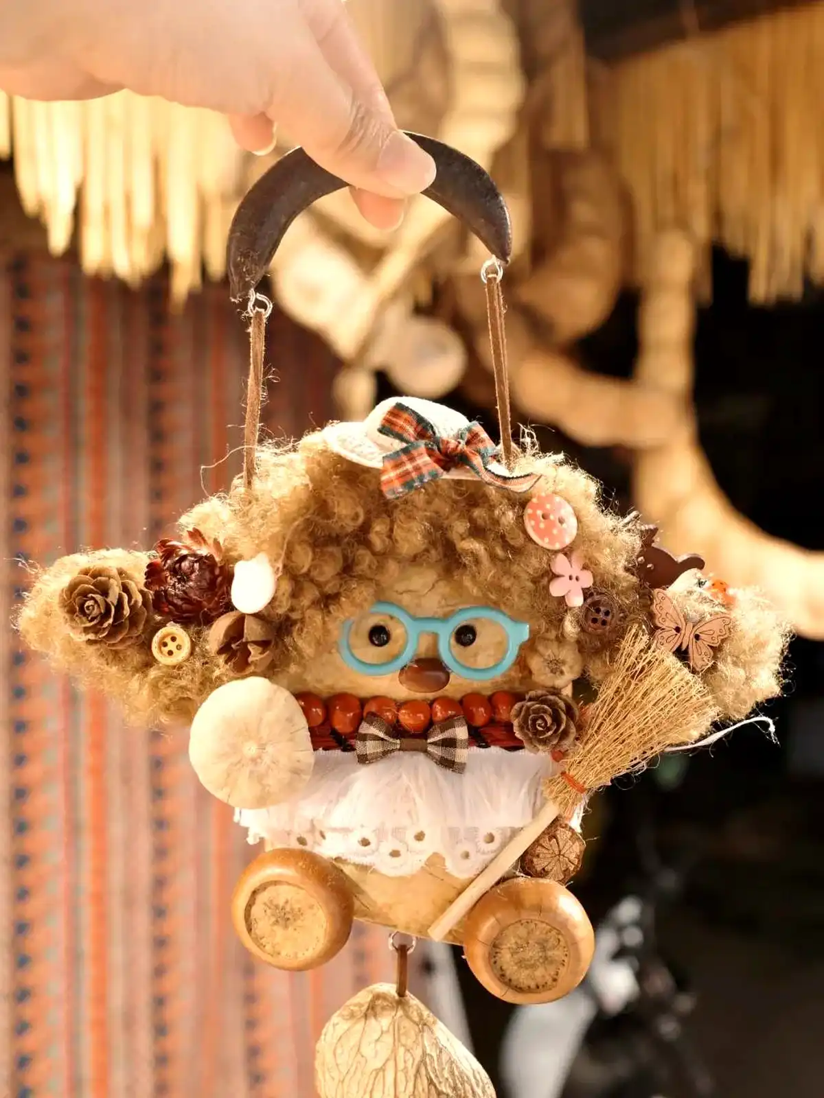 Handmade pod doll held in a cozy indoor display setting