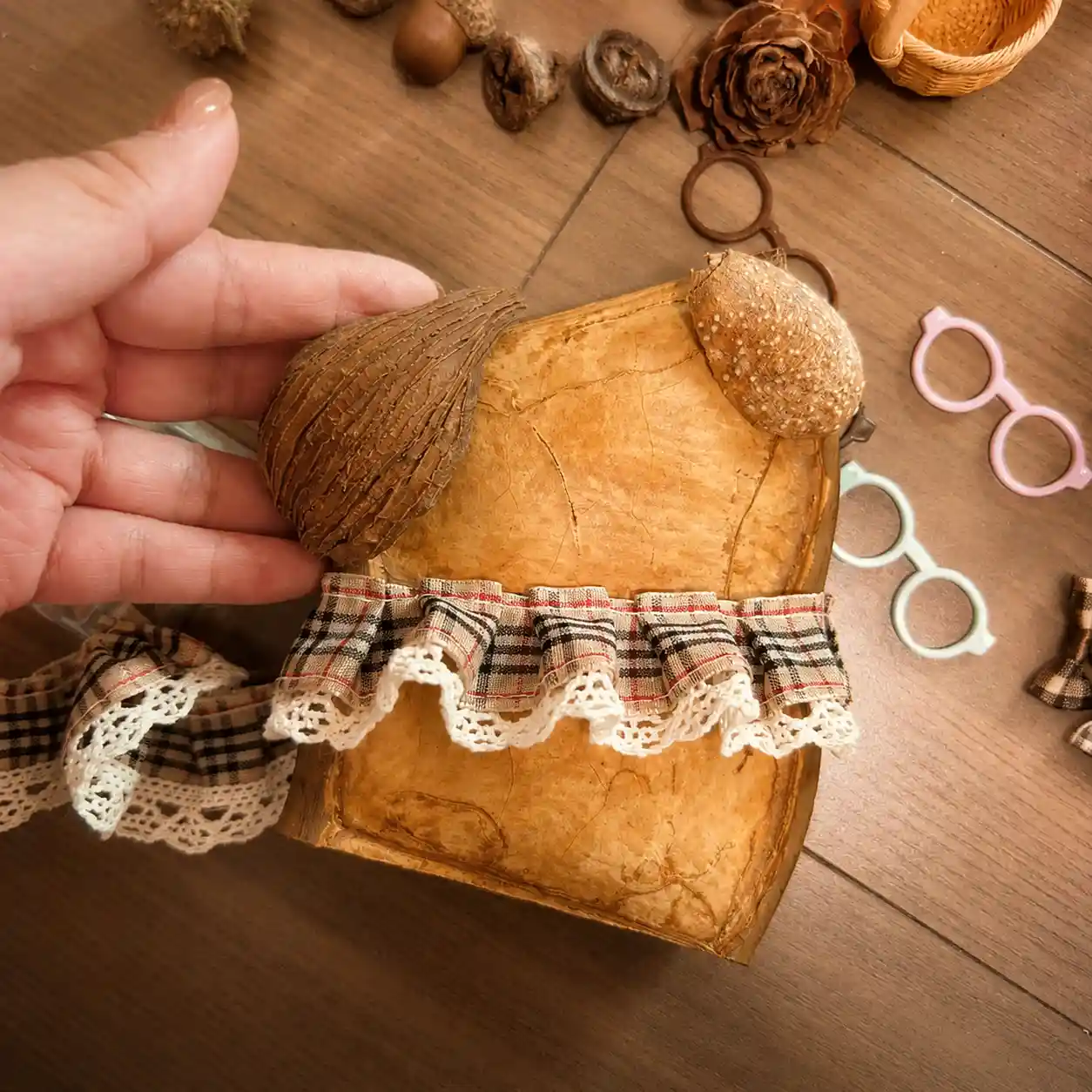 Handmade pod doll being made with natural seed pod and fabric details